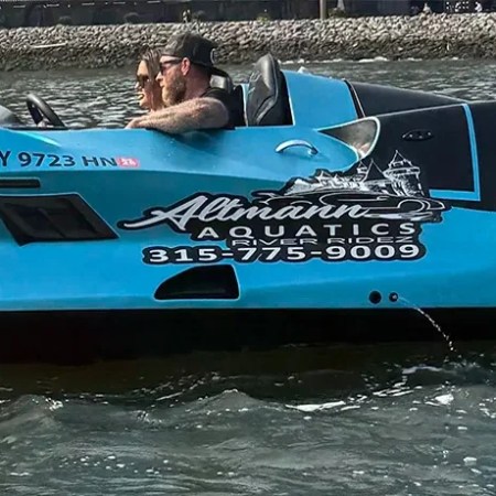 Blue jet car floating on water with person driving and text '1 Hour Jet Car Rental'.